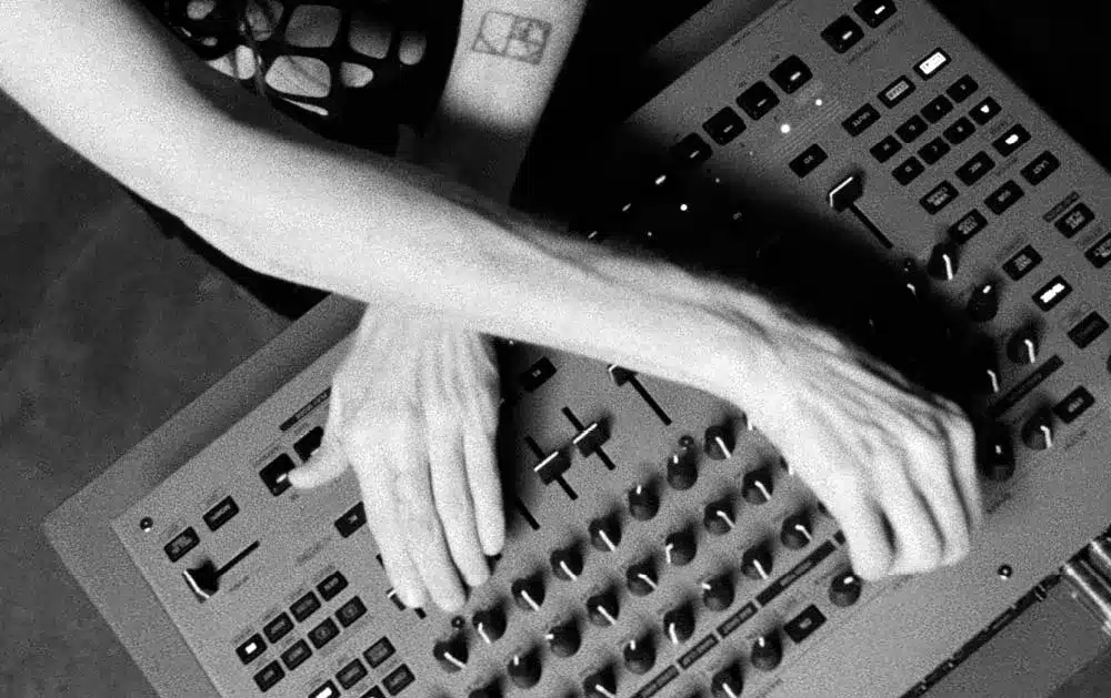 Roland TR-1000 Rhythm Creator en action en studio, gros plan sur les mains d'un musicien ajustant les potentiomètres et les commandes.